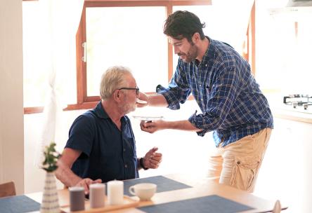 A man giving an older man medicine