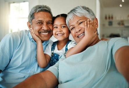 a grandchild hugs her grandparents