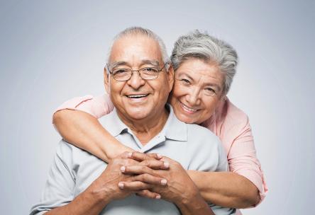 A woman hugging a man from behind.