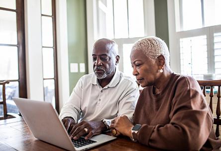 A couple looking at a laptop.
